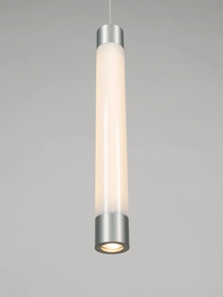 FUSE LED pendant light inspired by an automotive fuse, featuring a vertical illuminated form, acrylic cylindrical shade, and slim suspended cable for a floating appearance. Manufactured by Karice.