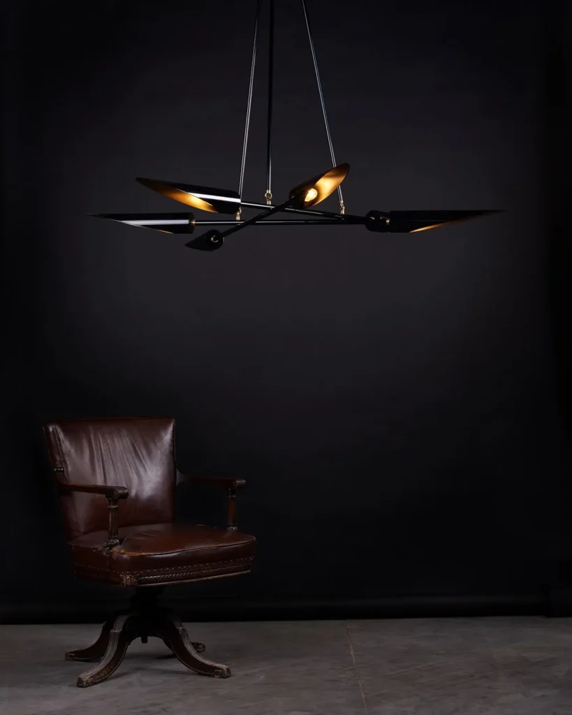Harmony mid-century chandelier with six lamps, brass accents, and a gloss black finish. Manufactured by Karice.