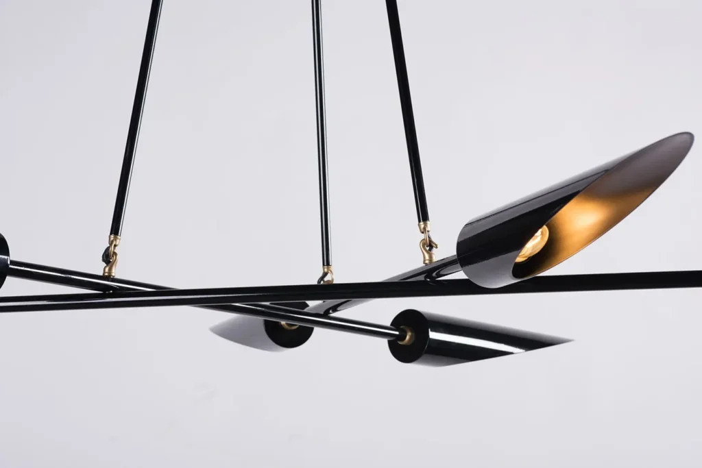 Harmony mid-century chandelier with six lamps, brass accents, and a gloss black finish. Manufactured by Karice.