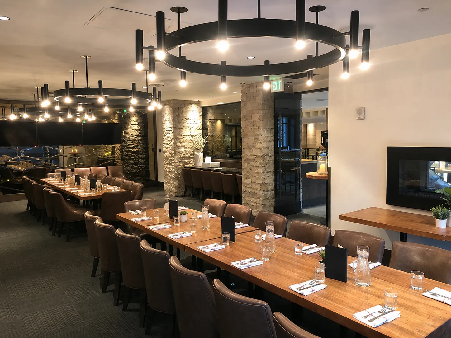 Custom modern black wagon wheel chandeliers for Earls Kitchen & Bar in Glenarm, Denver, CO, USA. Manufactured and designed by Karice.