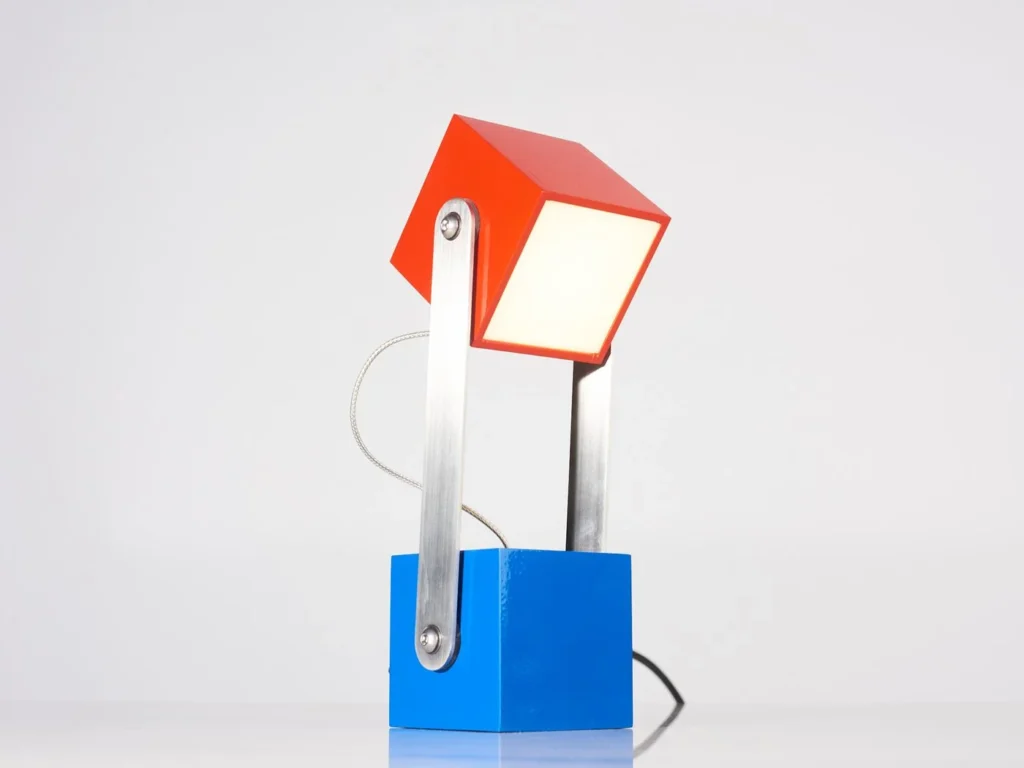 CUBE table lamp inspired by the Rubikโs Cube and Meccano sets, with an adjustable geometric design and multiple finish options. Designed and manufactured by Karice.