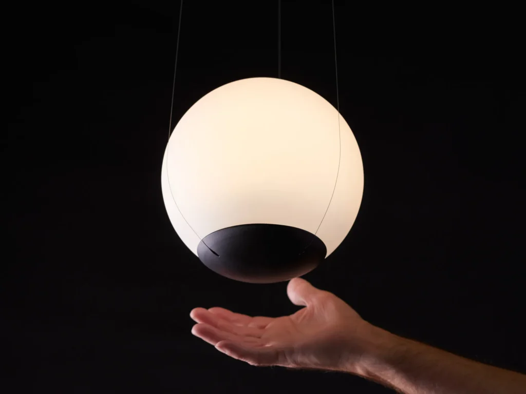 Eclipse pendant light with a perfect spherical form, suspended to appear weightless and floating, with dim-to-warm LED illumination. Designed and manufactured by Karice.