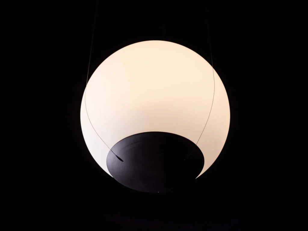 Eclipse pendant light with a perfect spherical form, suspended to appear weightless and floating, with dim-to-warm LED illumination. Designed and manufactured by Karice.