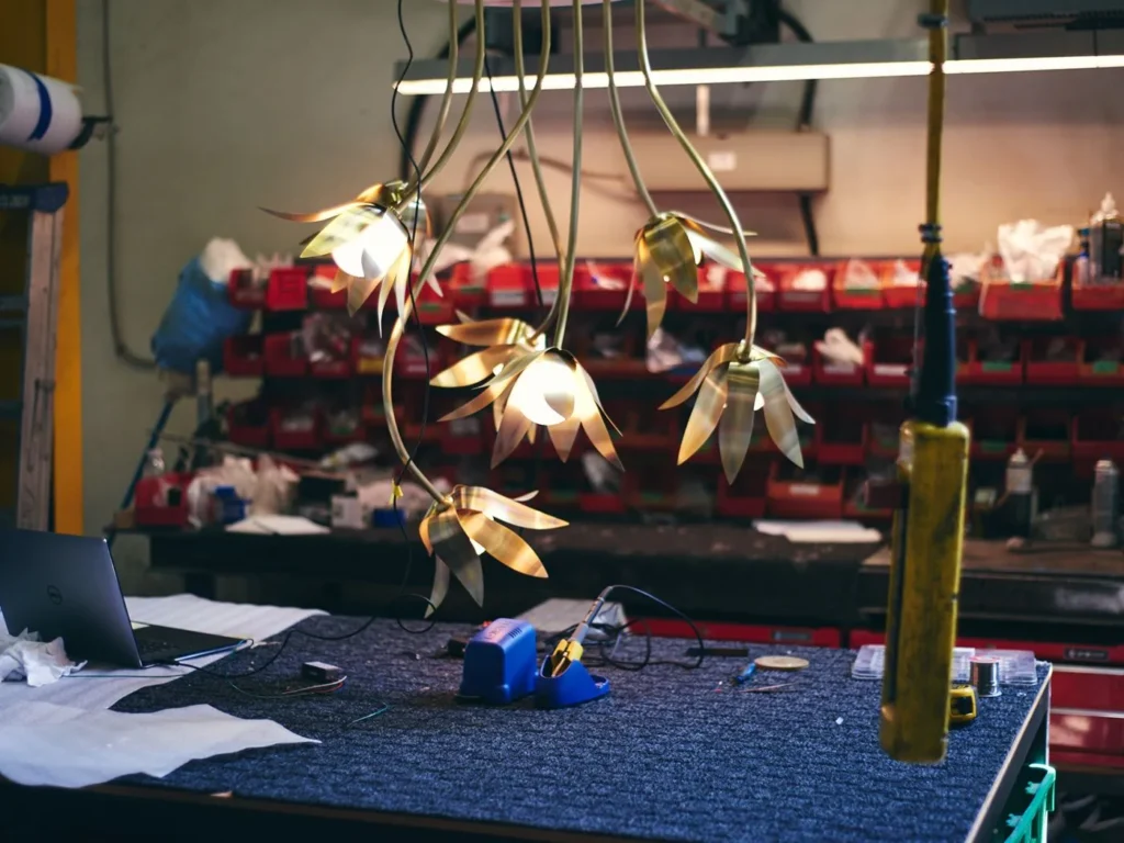 Bloom LED pendant with hand-blown glass and hand-formed brass petals, designed as a floral-inspired light fixture with dim-to-warm LED illumination. Designed and manufactured by Karice.