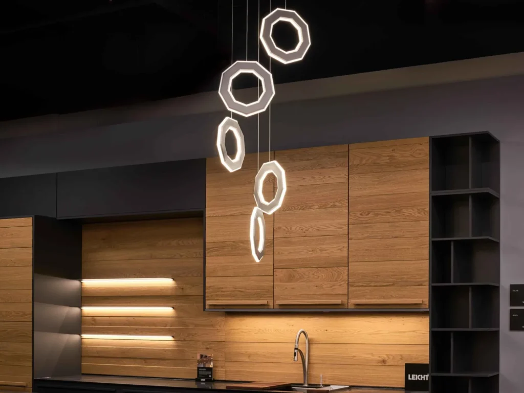 Ennea LED pendant with illuminated inner and outer geometric rings, concealed wiring, and suspended aluminum frame. Designed and manufactured by Karice.