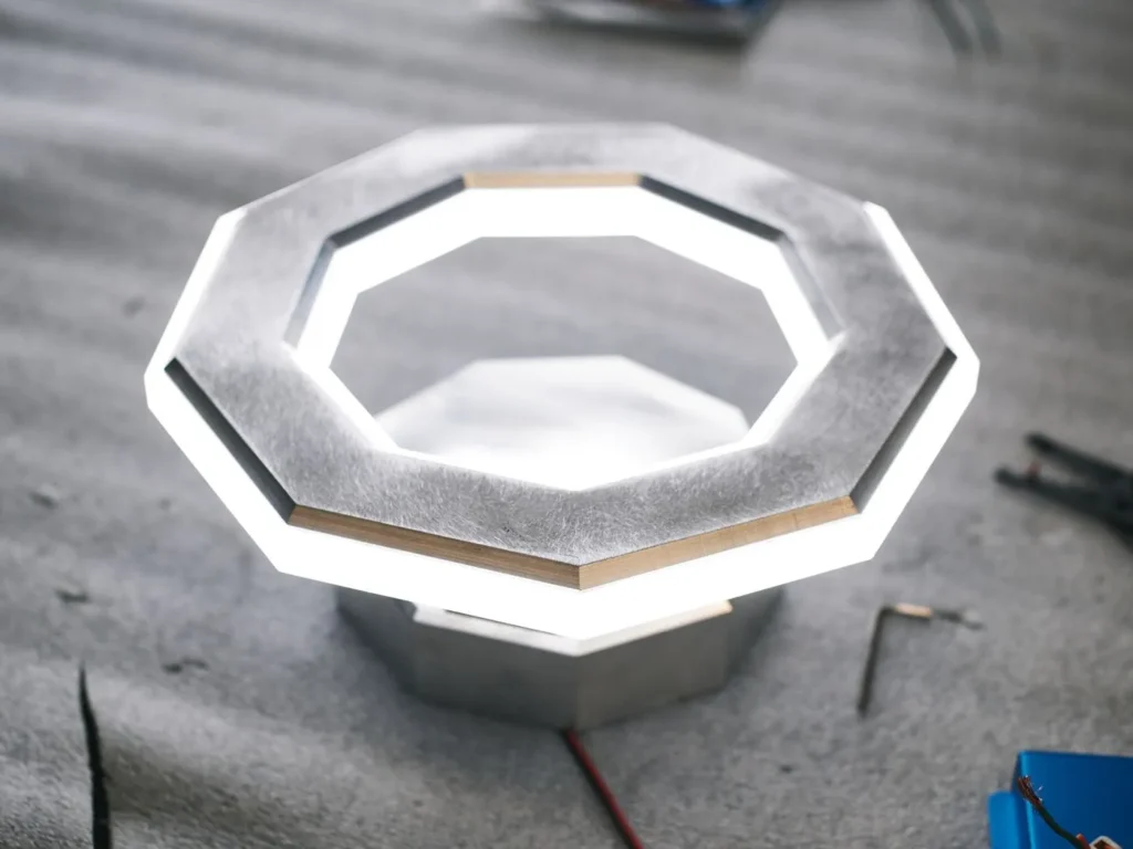 Ennea wall sconce with geometric rings, concealed fasteners, and dimmable inner and outer LED illumination. Designed and manufactured by Karice.