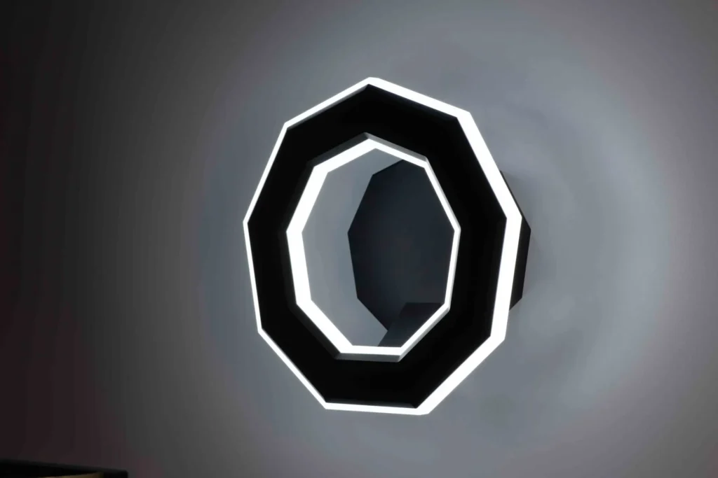 Ennea wall sconce with geometric rings, concealed fasteners, and dimmable inner and outer LED illumination. Designed and manufactured by Karice.