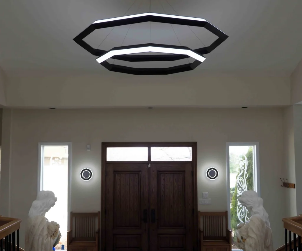 Ennea wall sconce with geometric rings, concealed fasteners, and dimmable inner and outer LED illumination. Designed and manufactured by Karice.