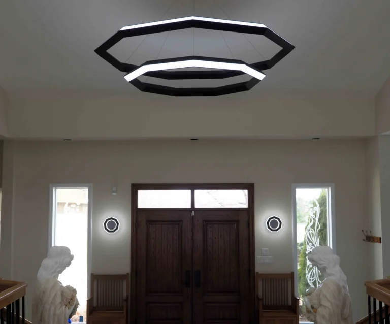 Ennea wall sconce with geometric rings, concealed fasteners, and dimmable inner and outer LED illumination. Designed and manufactured by Karice.