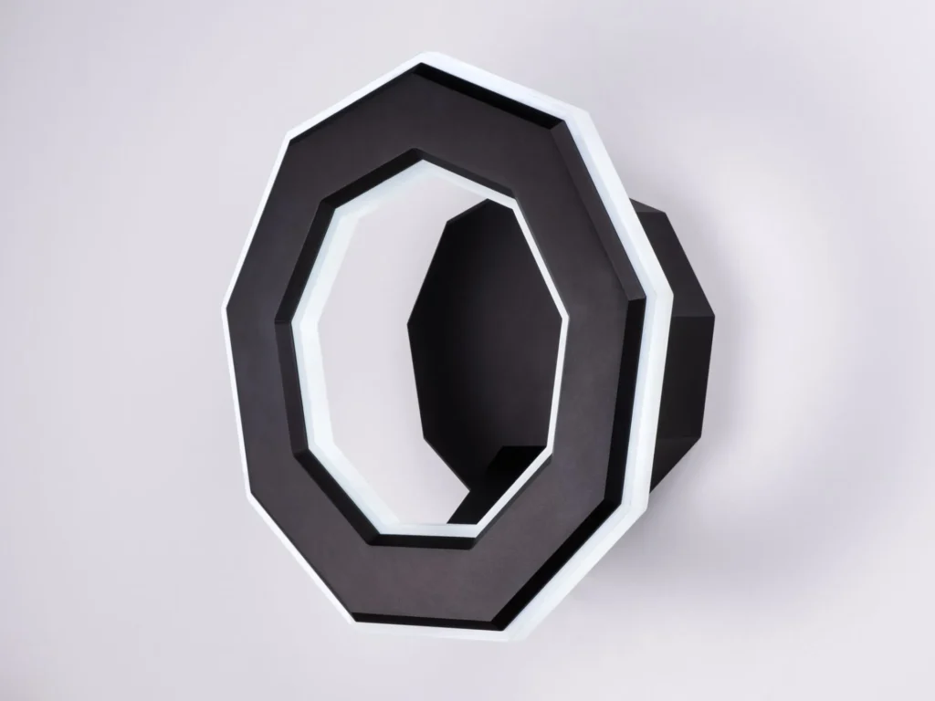 Ennea wall sconce with geometric rings, concealed fasteners, and dimmable inner and outer LED illumination. Designed and manufactured by Karice.