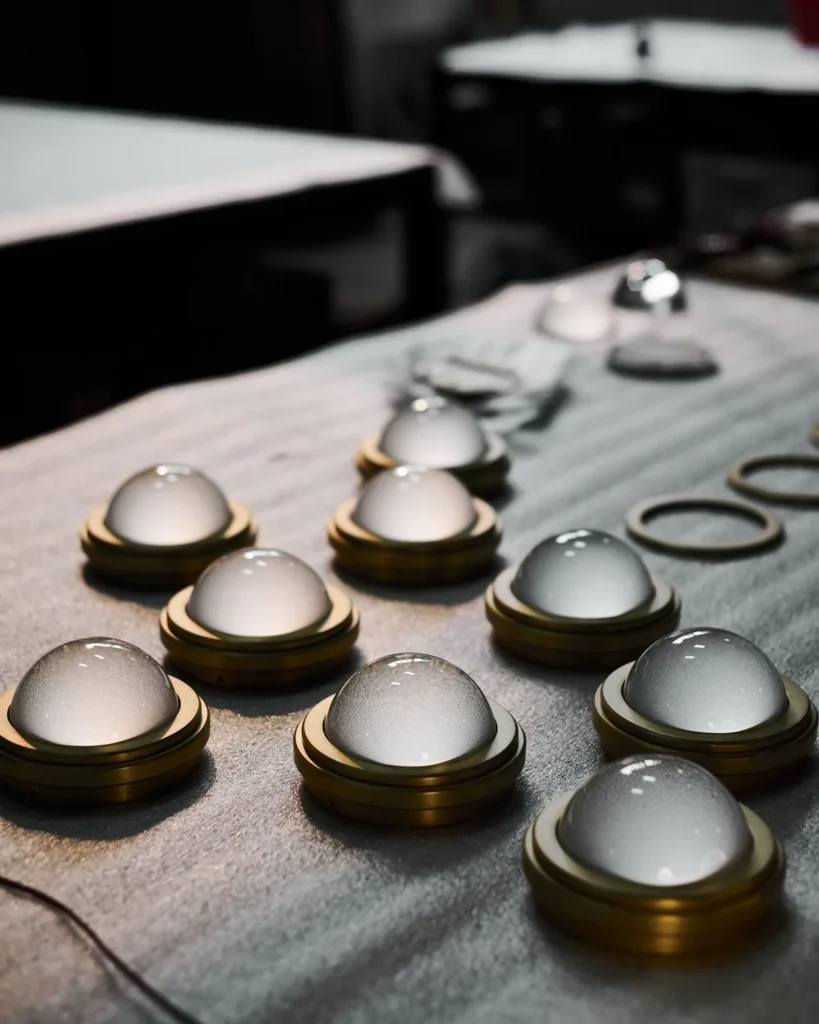 Infinity wall sconce with anodized aluminum, magnifying glass domes, concealed mounting plate, and adjustable illumination. Designed and manufactured by Karice.