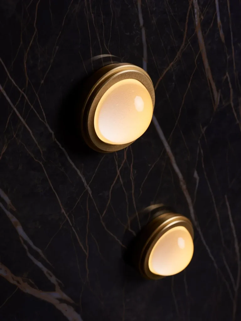 Infinity wall sconce with anodized aluminum, magnifying glass domes, concealed mounting plate, and adjustable illumination. Designed and manufactured by Karice.
