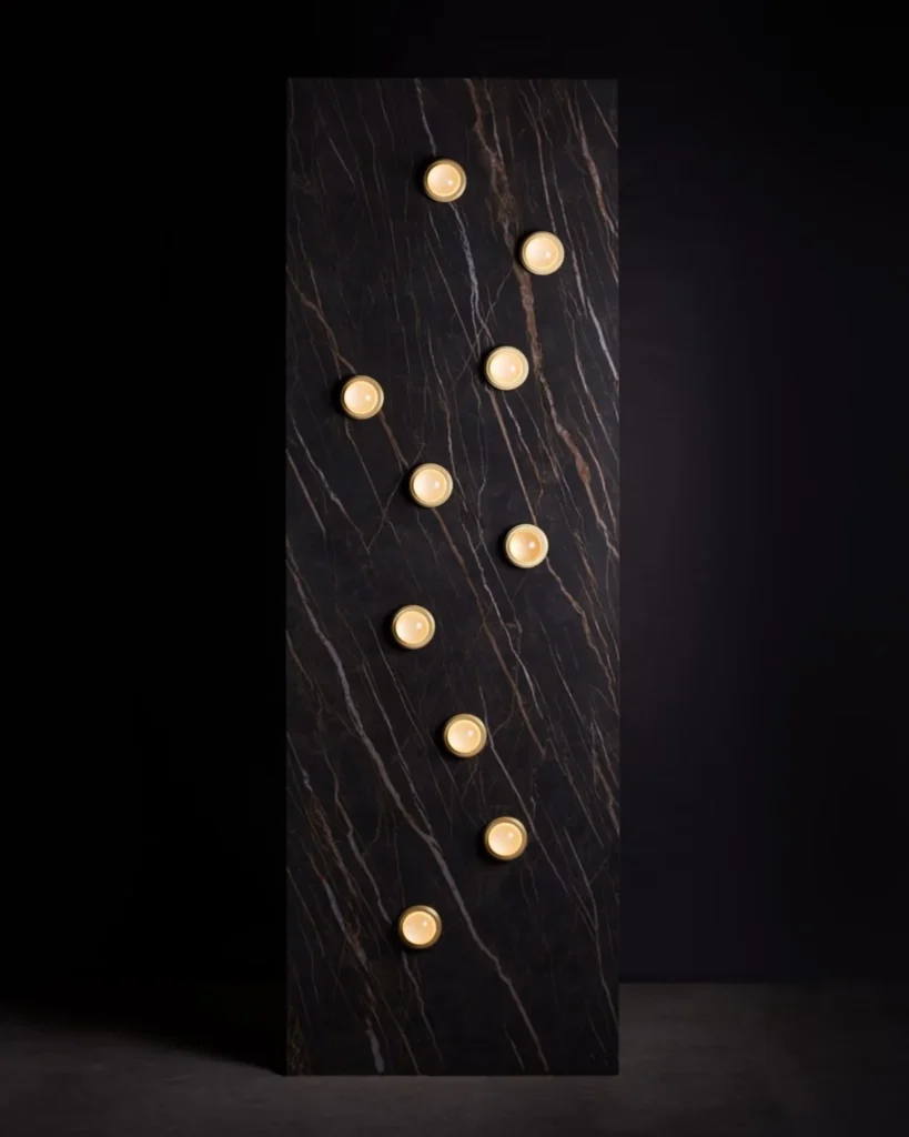 Infinity wall sconce with anodized aluminum, magnifying glass domes, concealed mounting plate, and adjustable illumination. Designed and manufactured by Karice.