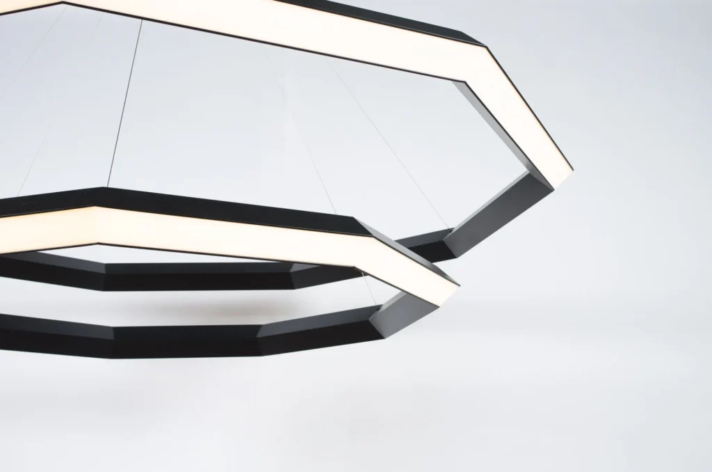 Luxennea Diamond sculptural chandelier with layered geometric tiers suspended by aircraft cables. Inspired by the Florentine Diamond. Designed and manufactured by Karice.