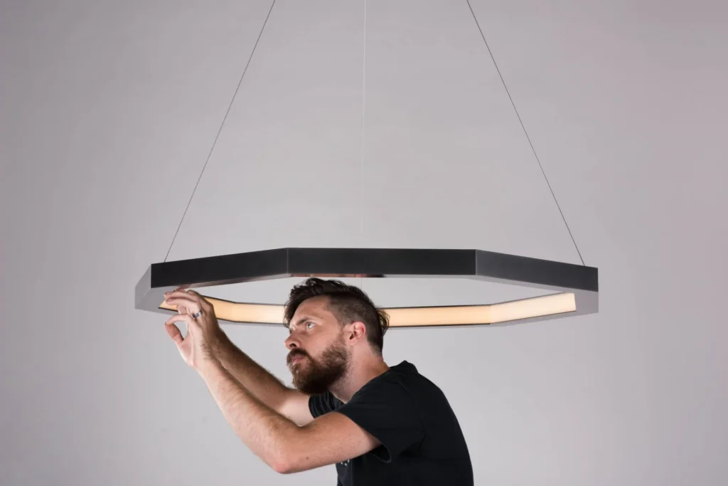 Luxennea Series 2 LED pendant with nine-sided geometric form, faceted aluminum construction, and inward diffused illumination. Designed and manufactured by Karice.