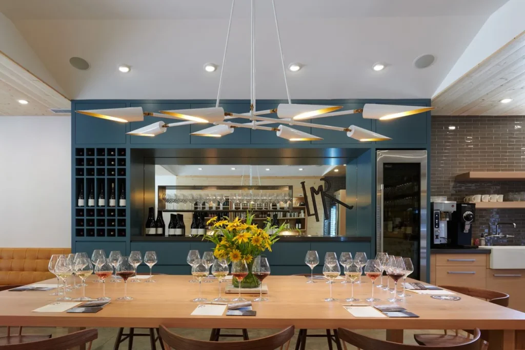 Octave mid-century chandelier with eight adjustable tilting shades, genuine brass swivels, and black or white finish options. Designed and manufactured by Karice.