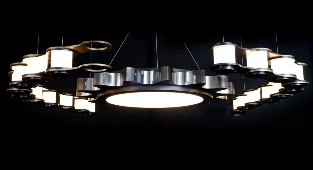The Sprocket and Chain 10-foot LED chandelier features an oversized gear-and-chain form, suspended by concealed aircraft cables and fasteners. Designed and manufactured by Karice.