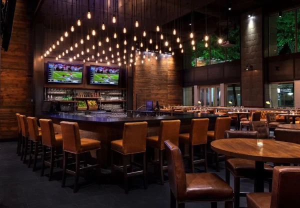 Custom multi-pendant filament bulb chandelier for Earls Kitchen & Bar in Hornby Street, Vancouver, BC, CA. Manufactured by Karice.
